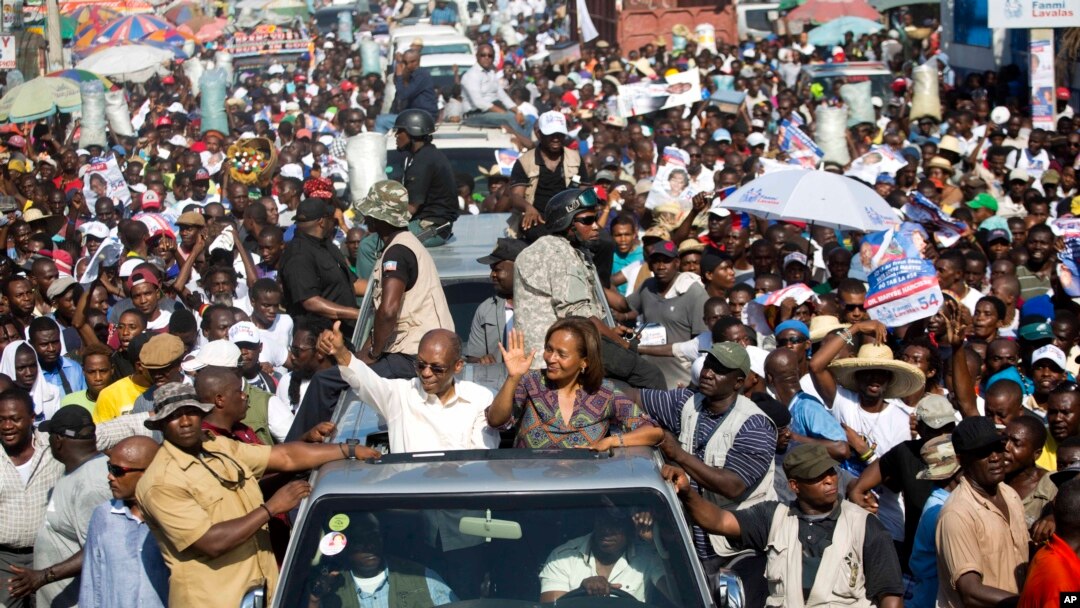 FILE -- Haiti's former President Jean-Bertrand Aristide, left, waves to supporters as he campaigns with presidential candidate Maryse Narcisse, of the Fanmi Lavalas political party, in Port-au-Prince, Haiti, in mid-September. Haiti will hold elections on 