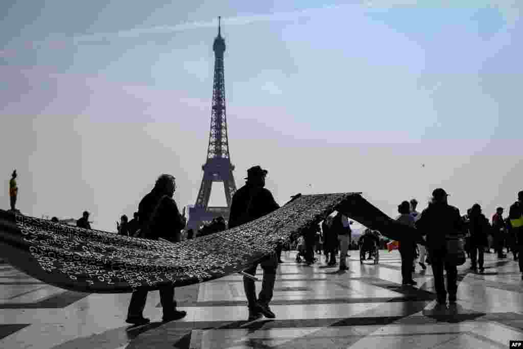 People carry a dark banner bearing the names of missing Colombian people in Paris, France, ahead of a march to the International criminal court (ICC) of the Hague by Colombian citizens in Europe to raise awareness on human rights abuses and the &#39;systematic assassination of social leaders&#39; in Colombia.