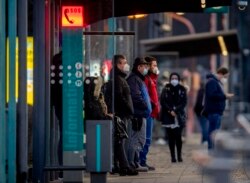 Warga mengenakan masker saat menunggu kereta di stasiun kereta bawah tanah di Frankfurt, Jerman, Jumat, 12 Maret 2021, di tengah meningkatnya kasus infeksi COVID-19. (Foto AP / Michael Probst)