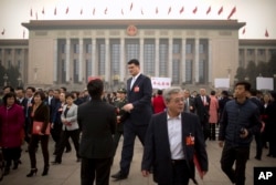 FILE - In this March 14, 2018, file photo, former NBA basketball player Yao Ming, center, a delegate to the Chinese People's Political Consultative Conference (CPPCC), leaves after a session at the Great Hall of the People in Beijing.