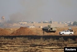 FILE - Free Syrian Army fighters along with Kurdish People's Protection Units (YPG) fighters gather at the eastern entrance to the town of Tel Abyad of Raqqa governorate.