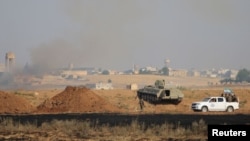 FILE - Free Syrian Army fighters along with Kurdish People's Protection Units (YPG) fighters gather at the eastern entrance to the town of Tel Abyad of Raqqa governorate.