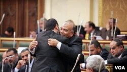 Ketua majelis rendah parlemen Mesir, Mohamed Saad el-Katatni (kanan) dari kelompok Ikhwanul Muslimin, menyalami para anggota parlemen dalam sidang pertama di Kairo (23/1).