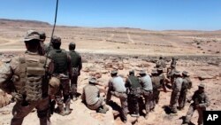 FILE - U.S. Marines monitor a multinational military training exercise in Quweira, 186 miles south of Amman, Jordan, June 18, 2013.