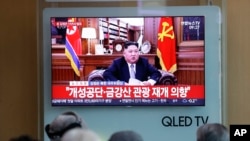 Orang-orang menyaksikan siaran pidato Tahun Baru pemimpin Korea Utara Kim Jong Un dari sebuah televisi di Stasiun Kereta Seoul, Korea Selatan, 1 Januari 2019.