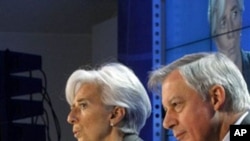 French Finance Minister Christine Lagarde gestures with Central Bank Governor Christian Noyer, right, during a press conference ending the G20 Finance summit at Bercy Finance Ministry in Paris, February 19, 2011