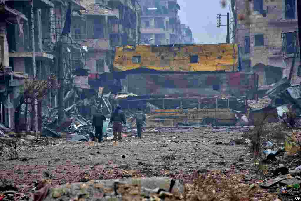 Syrian pro-government forces walk in Aleppo&#39;s Bustan al-Qasr neighborhood after they captured the area in the eastern part of the war torn city.