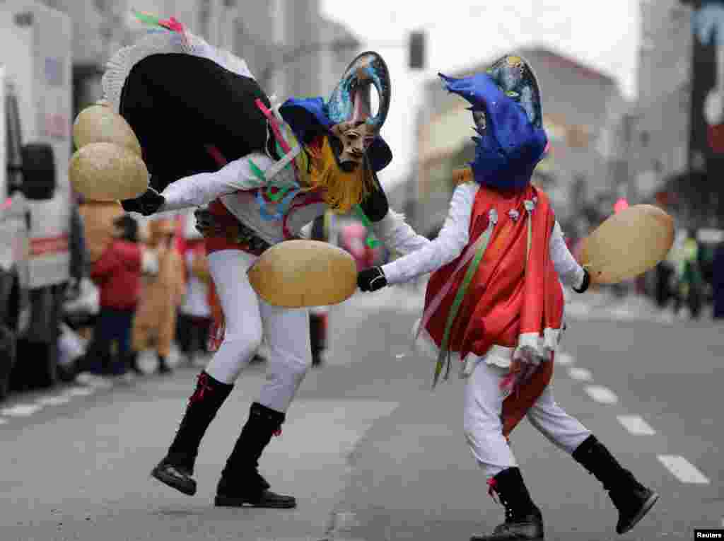 Revelers strike each other with pig bladders on a street during carnival celebrations in the northwestern village of Xinzo de Limia, Spain.