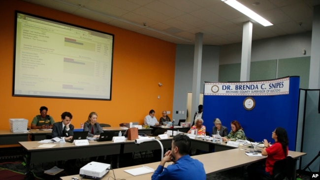 The Broward County Supervisor of Elections Canvasing Board reviews ballots cast in the U.S. midterm election, in Lauderhill, Florida, Nov. 9, 2018.