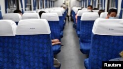 湖北武昌火車站裡戴著口罩的旅客在火車車廂裡休息。 （2020年4月8日）