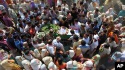 一名在印度東北部的曼尼普爾邦被反政府分子襲殺的軍人家屬和其他人士聚集在他的遺體身旁。（2015年6月7日）