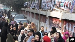 埃及人12月14日在一個選舉票站外為議會選舉進行第二輪投票。