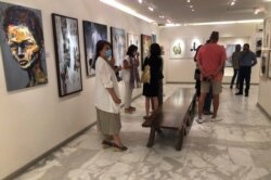 Pengunjung melihat karya seni dalam pameran yang diadakan untuk penggalangan dana bagi Gaza, di Galeri Orient, Amman, Yordania, 25 Mei 2021. (REUTERS / Jehad Shelbak)