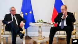 Russian President Vladimir Putin, right, gestures as he listens to European Commission President Jean-Claude Juncker during their talks at the St. Petersburg International Economic Forum in St.Petersburg, Russia, June 16, 2016. 