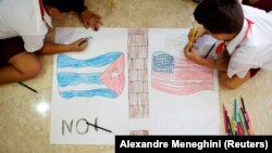 Des enfants dessinent des drapeaux de Cuba et des États-Unis au cours du XIVe Forum de la société civile contre l'embargo économique et commercial permanent de 55 ans contre Cuba à La Havane, Cuba, le 18 octobre 2017.