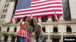 中国游客在华尔街纽约证券交易所前用手机自拍。（2015年7月8日）