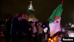 People pay their respects at a make-shift memorial following a vigil held in honor of the victims of a shooting in a mosque in Quebec City, Canada, Jan. 30, 2017.