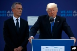 FILE - NATO Secretary-General Jens Stoltenberg listens as President Donald Trump speaks during a ceremony to unveil artifacts from the World Trade Center and Berlin Wall for the new NATO headquarters in Brussels, May 25, 2017.
