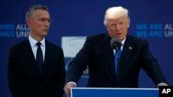 NATO Secretary General Jens Stoltenberg listens as President Donald Trump speaks during a ceremony to unveil artifacts from the World Trade Center and Berlin Wall for the new NATO headquarters in Brussels, May 25, 2017. 