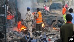FILE - Somali soldier inspect wreckage of vehicles after a car bomb that was detonated in Mogadishu, Oct 28, 2017. 