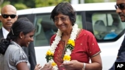 Ethnic Tamil girl presents floral garland to welcome U.N. High Commissioner for Human Rights, Navi Pillay, Kilinochchi, Sri Lanka, Aug. 27, 2013.