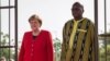 La chancelière allemande Angela Merkel (à gauche) aux côtés du président du Burkina Faso, Roch Marc Christian Kabore (à droite) lors d'une cérémonie de bienvenue au palais présidentiel de Ouagadougou le 1er mai 2019.