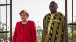 La chancelière allemande Angela Merkel (à gauche) aux côtés du président du Burkina Faso, Roch Marc Christian Kabore (à droite) lors d'une cérémonie de bienvenue au palais présidentiel de Ouagadougou le 1er mai 2019.