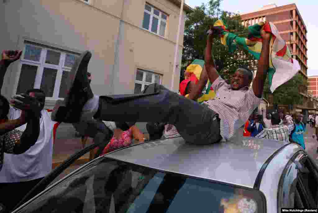 Zimbabueanos celebram nas ruas à porta do parlamento após o anúncio da resignação de Robert Mugabe