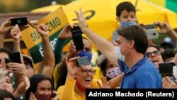 Le président brésilien Jair Bolsonaro saluant ses partisans durant la pandémie de COVID-19, à Brasilia, le 17 mai 2020. (REUTERS/Adriano Machado)