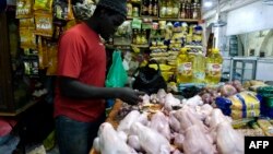 Un vendeur de poulets prépare des viandes à vendre sur un marché de Bambilors à Dakar, le 4 mai 2018.