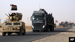 A convoy of Iraqi military vehicles heads toward Qayyarah base in northern Iraq, ahead of an expected offensive to retake Mosul from Islamic State militants, Oct. 15, 2016.
