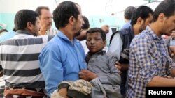9일 예멘 북부 반군 장악 지역인 사다 주의 자흐얀에서 아랍연합군이 어린이들이 탄 버스를 폭격한 가운데 남성이 부상한 어린이를 옮기고 있다. 