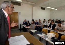 FILE - A professor gives a lecture to students at the College of Administration and Economy in Baghdad University, March 16, 2009.