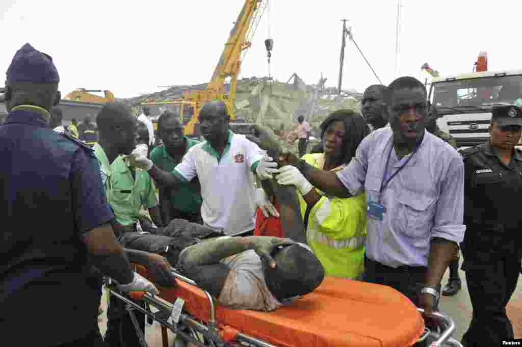 Rescue workers carry a wounded man out from the debris of a collapsed building, Accra, Ghana, November 7, 2012. 