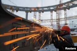 FILE - A laborer works at the Yekaterinburg Arena stadium under construction, that will host 2018 FIFA World Cup matches, in Yekaterinburg, Russia, Dec. 9, 2016. Reports of forced labor and corruption have overshadowed preparations for the tournament.