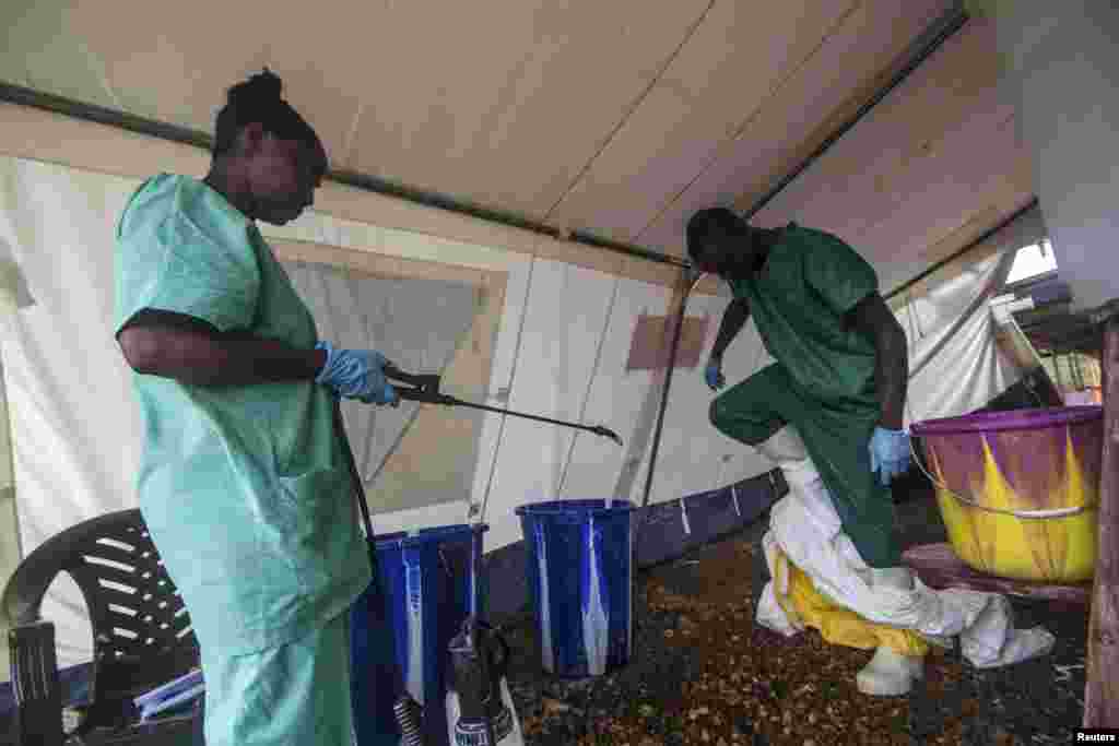 A health worker removes his protective suit as he emerges from an isolation area at the Medecins Sans Frontieres Ebola treatment center, in Kailahun, July 20, 2014. 