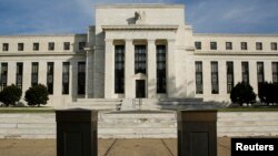 FILE - The U.S. Federal Reserve Board building is shown behind security barriers in Washington.