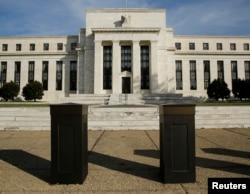 FILE - The U.S. Federal Reserve Board building is shown behind security barriers in Washington.