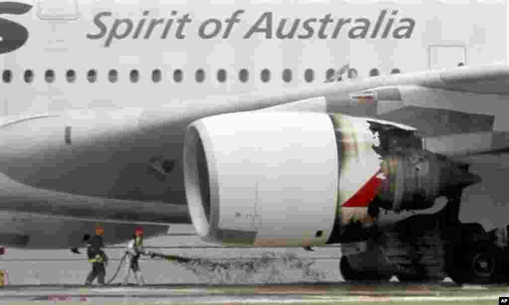 Firefighters surround a Qantas passenger plane which made an emergency landing with 459 people aboard in Singapore's Changi International Airport after having engine problems Thursday, Nov. 4, 2010. (AP Photo/Wong Maye-E)