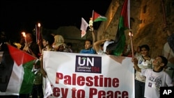 Palestinians take part in a candle light rally outside the Church of the Nativity, in the West Bank town of Bethlehem, to show support for the Palestinian bid for full United Nations membership, September 15, 2011.