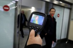 Kazakhstan, Almaty, Kazakh sanitary-epidemiological service worker uses a thermal scanner to detect travellers from China