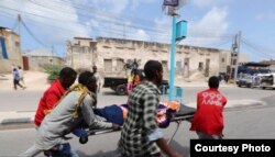 FILE - An Aamin Ambulance team transports a body after a bombing at the Somali interior ministry compound in Mogadishu, July 9, 2018.