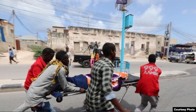 FILE - An Aamin Ambulance team transports a body after a bombing at the Somali interior ministry compound in Mogadishu, July 9, 2018.