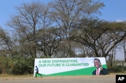 A man walks past a banner ahead of Sunday's inauguration of Zimbabwean President Emmerson Mnangagwa in Harare, Zimbabwe, Aug, 25, 2018.