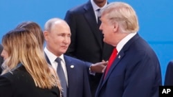 Президент Дональд Трамп, праворуч, проходить повз президента Росії Володимира Путіна, зліва, коли вони збираються на групову фотографію на початку саміту "великої двадцятки" в Буенос-Айресі, Аргентина, у п'ятницю, 30 листопада 2018 року. 