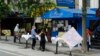 Përpara një restoranti në Nju Jork, klientët qëndrojnë në tavolina të vendosura përkohësisht në trotuar