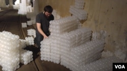 Alex Sceery building a spiral staircase with cubes made with plastic balls. (D. Block/VOA)