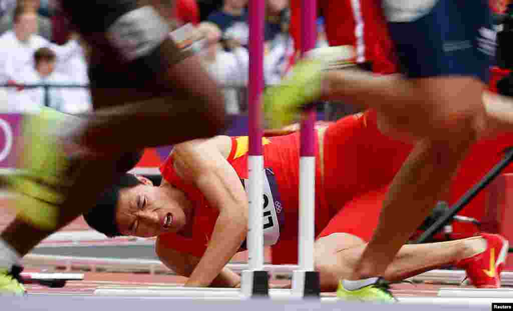 China's Liu Xiang falls after hitting a hurdle in his men's 110m hurdles round 1 heat, clutching the same right Achilles tendon that doomed his chances at the Beijing Games in 2008.