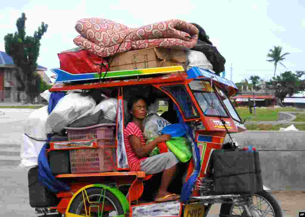 Typhoon survivors, some of whom are still living in tents, evacuate to safer ground with their belongings at the Tanauan township, Leyte province in central Philippines in anticipation of the incoming Typhoon Hagupit which is forecast to hit central part of the country this weekend.