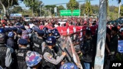 Police block protesters as they gather near a statue of General Aung San during a demonstration in Loikaw, Myanmar, Feb. 12, 2019.
